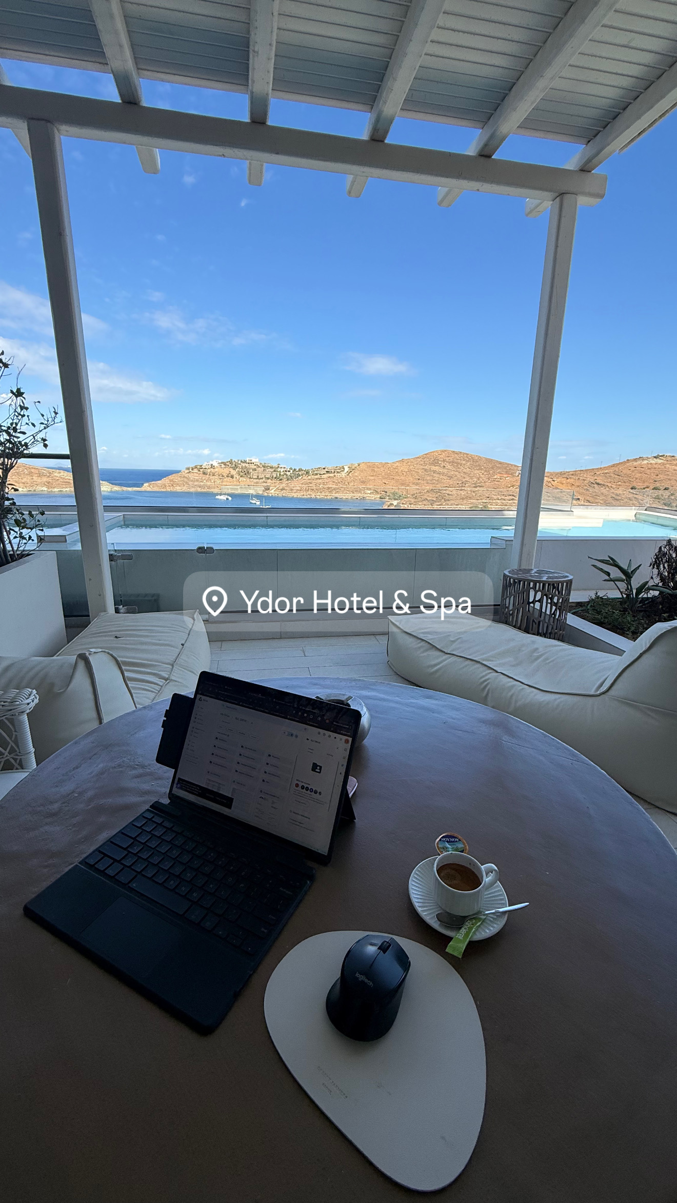 Tablet, coffee, and infinity pool view at Ydor Hotel
